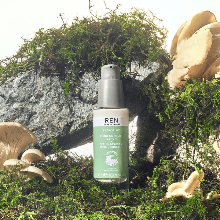 REN Evercalm Redness Relief Serum 30 ml beroligende serum mod rødme i flaske omgivet af mos og hvide svampe.