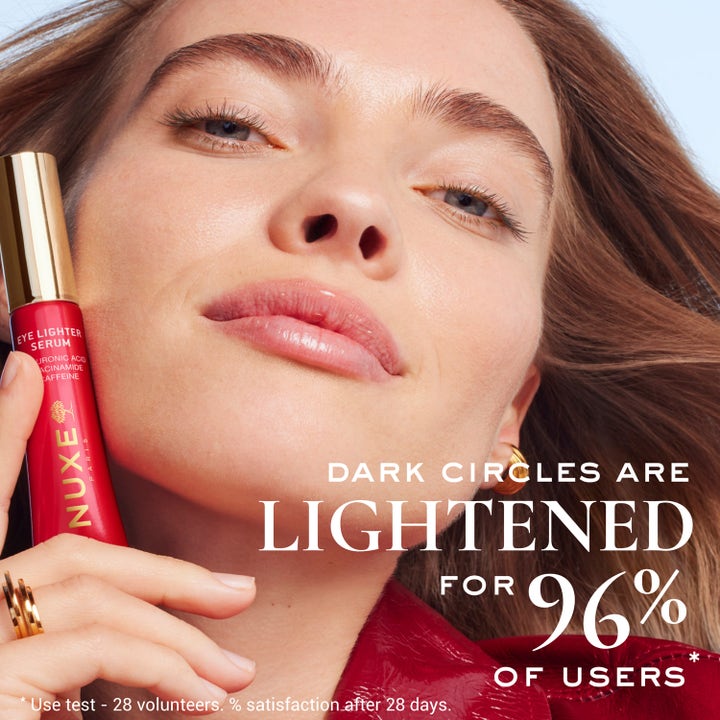 Nuxe Merveillance Lift Eye-Lighter Serum 12 ml mod mørke rande i rød tube holdt af en kvinde