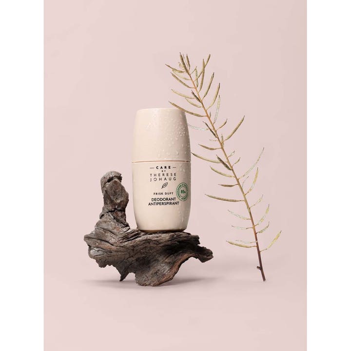 Care by Therese Johaug Frisk Deo 50 ml antiperspirant giver friskhed i beige roll-on på rustikt træ med en tørret gren