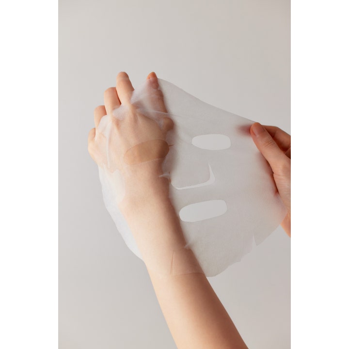 Some By Mi Retinol Intense Daily Mask 30 stk ansigtsmaske viser en tynd hvid sheet mask der holdes i hænderne.