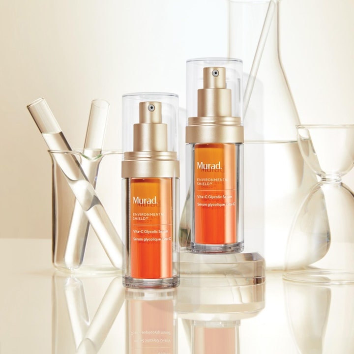 Murad Vita-C Glycolic Serum 30 ml giver glød med C-vitamin i to orange pumpeflasker foran laboratorieglas