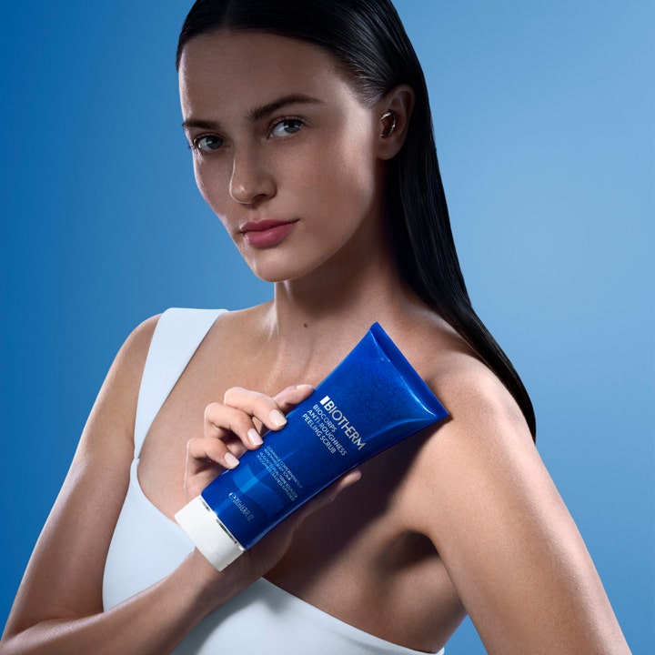 Biotherm Biocorps Body Scrub 200 ml udglattende kropsskrub mod ru hud i blå tube holdt af en kvinde