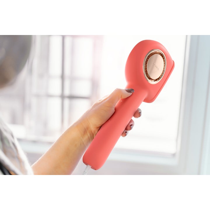 FOREO PEACH™ 2 Pro Max 1 stk til hårfjerning i ferskenfarvet design med gulddetaljer holdt i en hånd