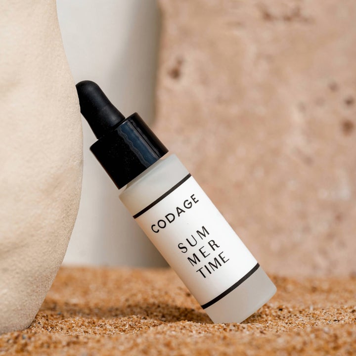 Codage Paris Summer Time Serum 10 ml beskyttende ansigtsserum i matteret glasflaske med sort pipette stående i sand