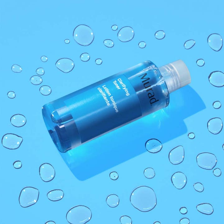 Murad Blemish Control Clarifying Toner 180 ml rensende ansigtsvand i blå gennemsigtig flaske blandt vanddråber