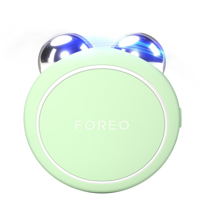 Foreo Bear opstrammende ansigtsapparat i mintgrøn silikone med to blanke sølvkugler og blåt lys.