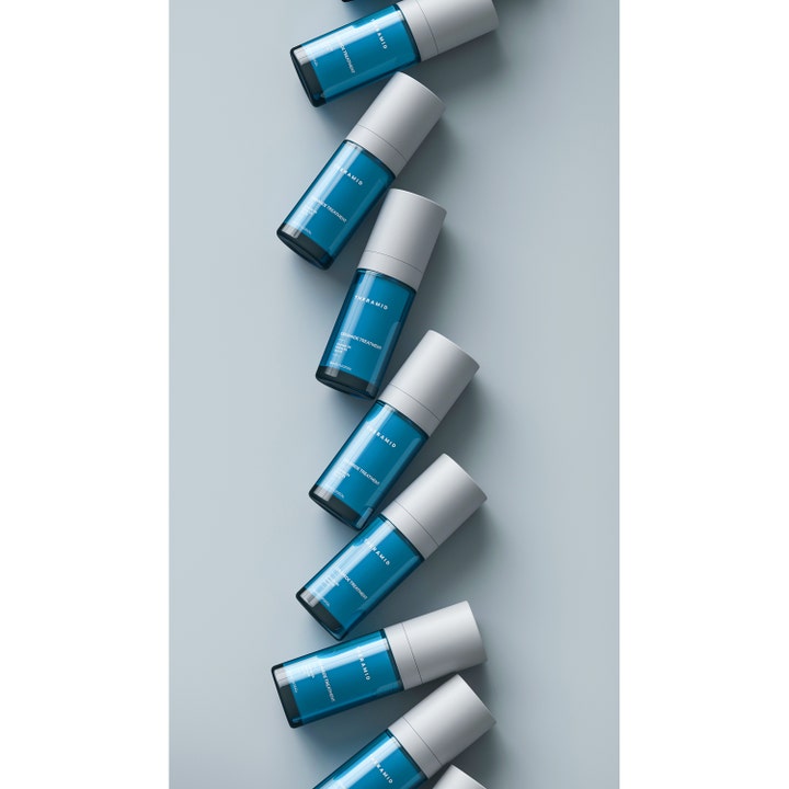 Niche Beauty Lab Theramid Ceramide Treatment 30 ml styrkende ansigtsserum i blå flasker i et diagonalt mønster.