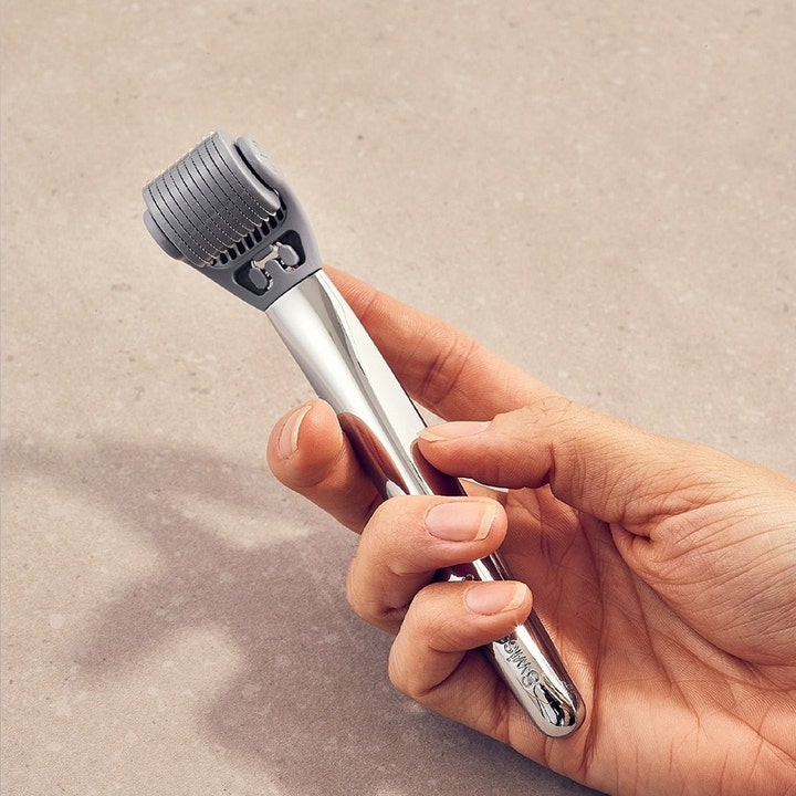 Swiss Clinic Skin Roller 0,5 mm 1 stk dermaroller til ansigtspleje med sølvfarvet metalhåndtag holdt i en hånd