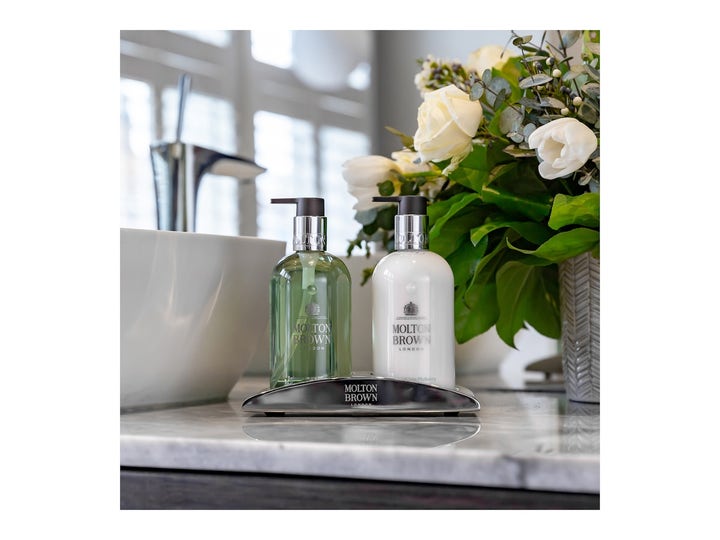 Molton Brown Refined White Mulberry 300 ml håndsæbe i gennemsigtig flaske ved siden af hvid lotion på marmorbord