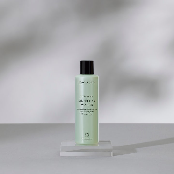 Löwengrip Clean & Calm Micellar Water 230 ml beroligende ansigtsrens i lysegrøn flaske på en gennemsigtig blok.