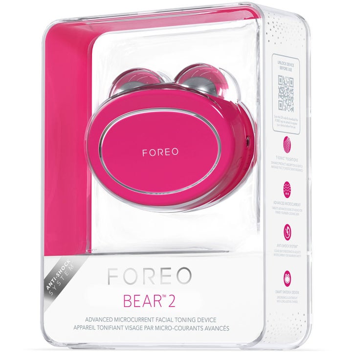FOREO BEAR 2 fuchsia ansigtsapparat til opstrammende mikrostrøm i gennemsigtig salgsæske med sølvkugler.