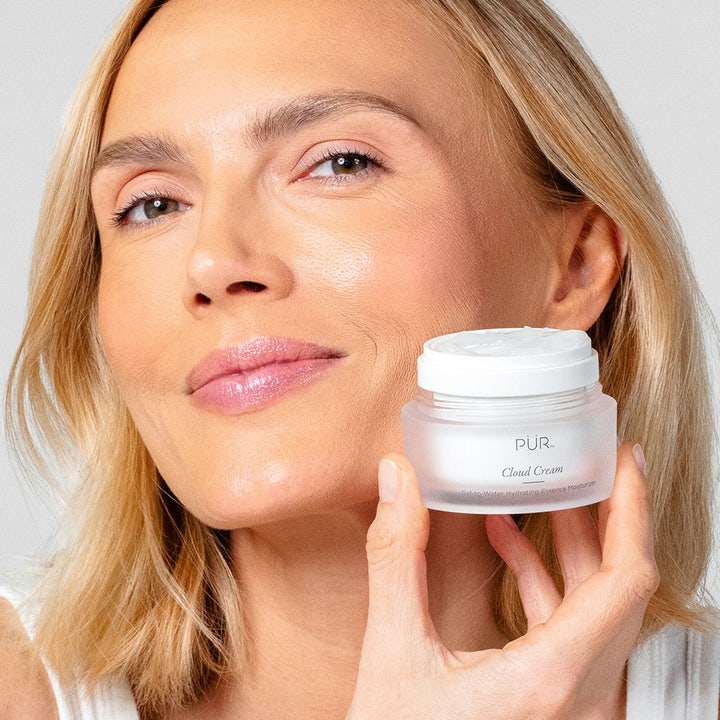 PÜR Cloud Cream 50 ml fugtgivende ansigtscreme i glasburk holdt af model med glødende hud