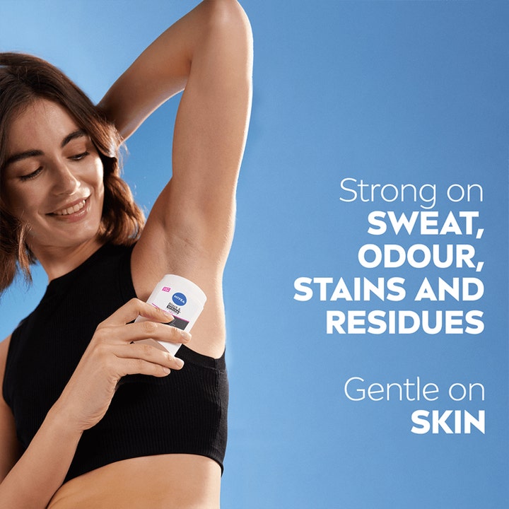 NIVEA Black & White Anti-Perspirant Stick 50 ml mod sved og pletter påføres af kvinde i armhulen på blå baggrund