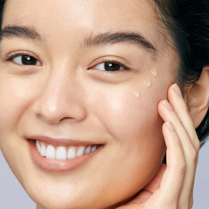 Mario Badescu Hyaluronic Dew Drops 29 ml hyaluronsyraserum giver fugt vist med klare dråber på en smilende kind.