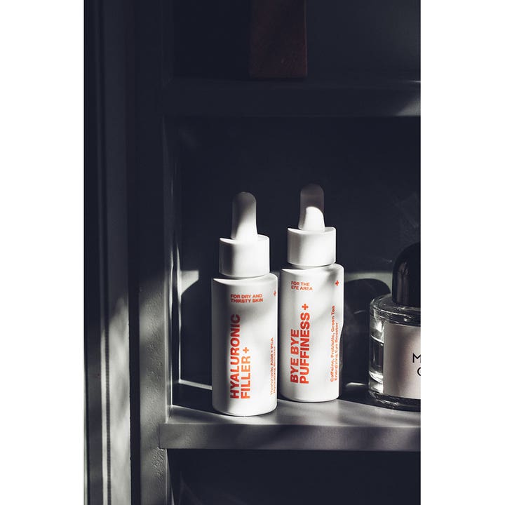 Swiss Clinic Hyaluronic Filler+ 30 ml fugtgivende serum i hvid flaske med pipette på en hylde i skyggefuldt lys