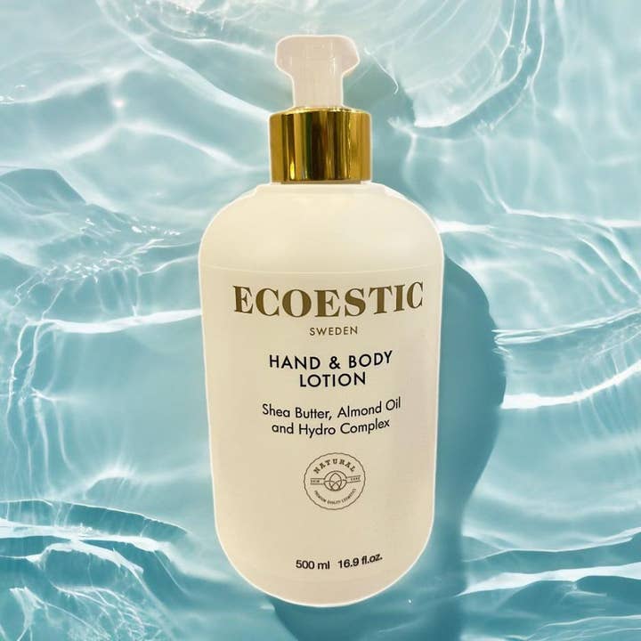 ECOESTIC Hand & Body lotion 500 ml fugtgivende bodylotion med sheasmør i beige flaske med guldpumpe over vand