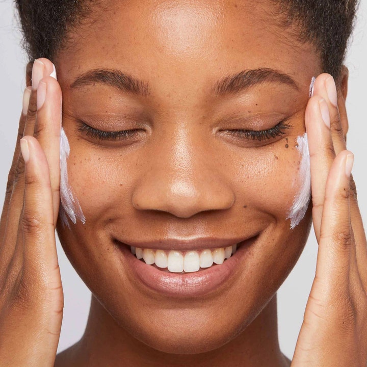 Dermalogica Invisible Physical Defense SPF30 50 ml solcreme til ansigtet påføres på kinderne af en smilende kvinde