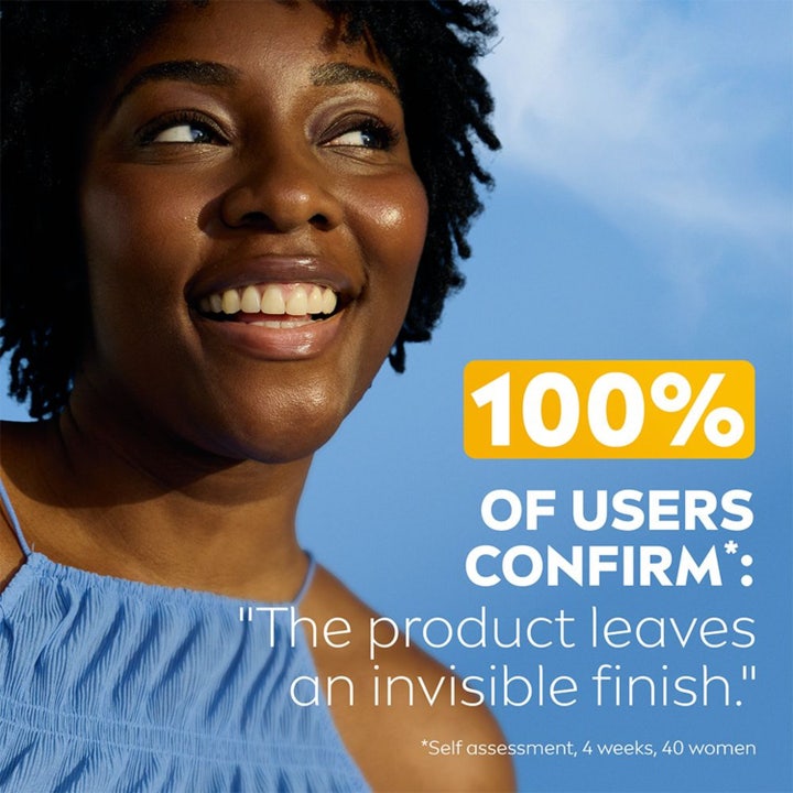 NIVEA UV Face Invisible Daily Fluid 40 ml solcreme ansigt giver usynlig finish på smilende kvinde mod blå himmel