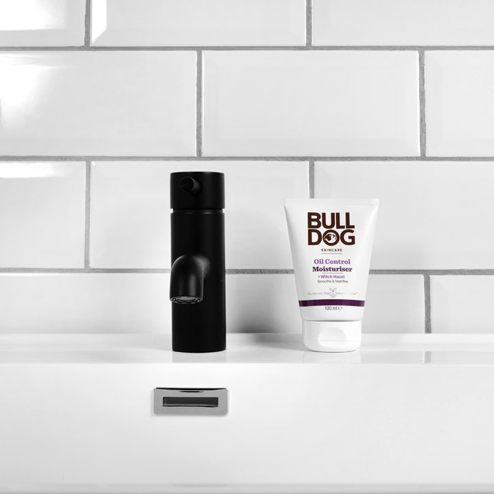 Bulldog Oil Control Moisturiser 100 ml matterende ansigtscreme i hvid tube ved siden af en sort vandhane på en vask