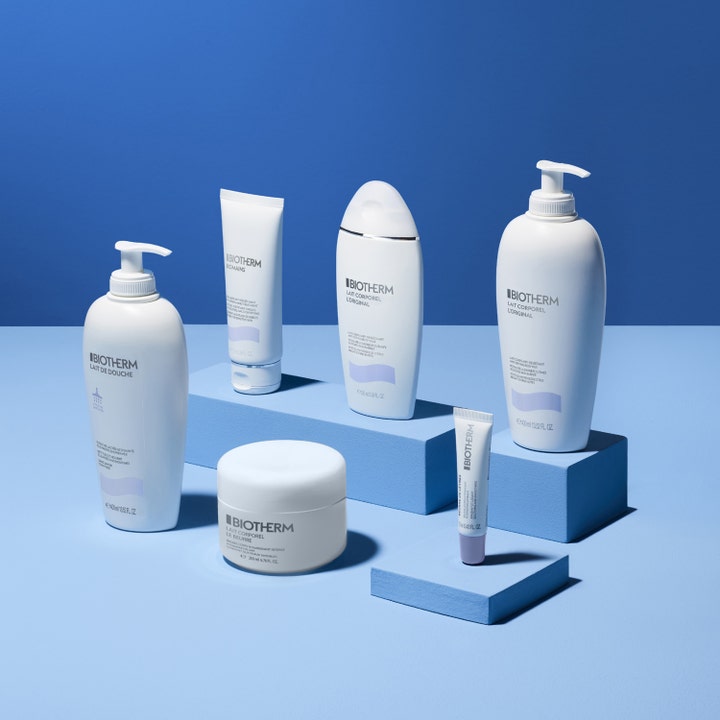 Biotherm Lait Corporel Moisturizing Shower Milk 200 ml fugtgivende bademælk i hvide flasker på lyseblå podier