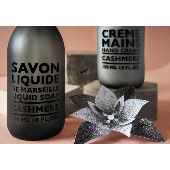 Compagnie de Provence Liquid Marseille Soap Cashmere 300 ml håndsæbe i mat sort glasflaske ved en dekorativ blomst