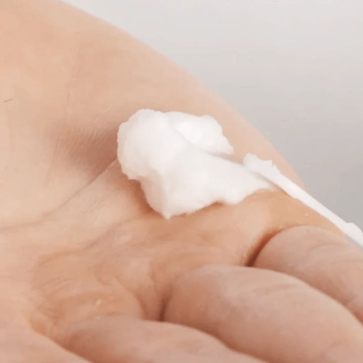 Codage Paris The Scrubbing Cream 50 ml eksfolierende ansigtsscrub med en hvid cremet tekstur på en håndflade