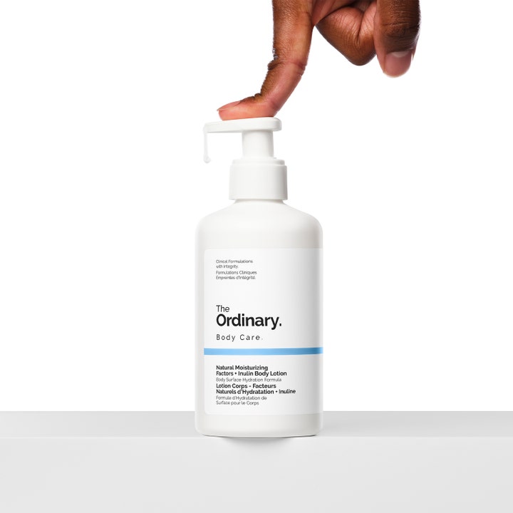 The Ordinary NMF + Inulin Body Lotion 240 ml fugtgivende kropspleje i hvid flaske hvor en finger trykker på pumpen