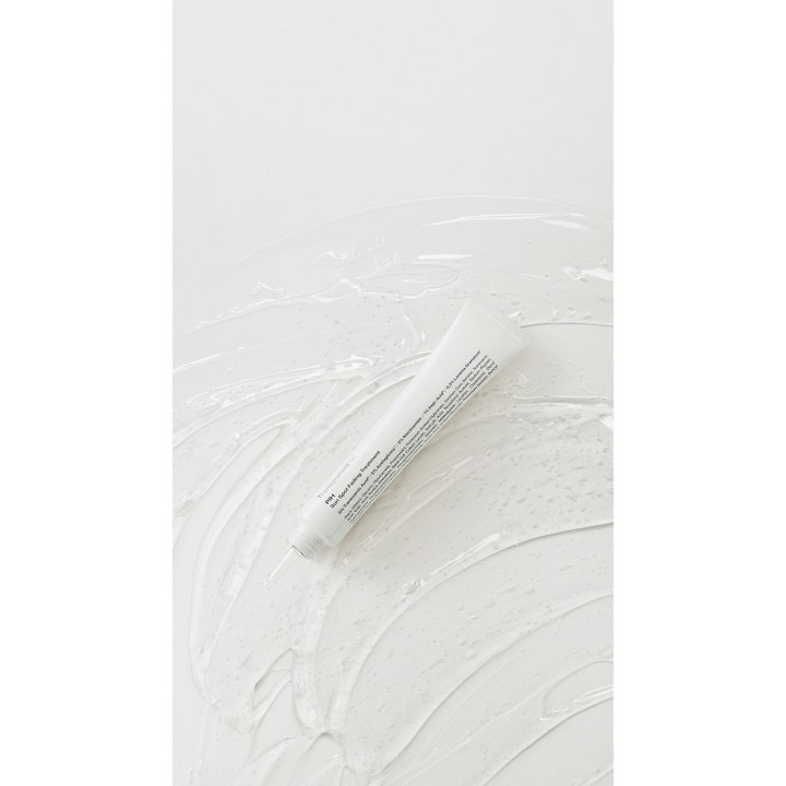 Niche Beauty Lab Transparent Lab P.I.H 30 ml spot treatment i hvid tube placeret på en klar gel-tekstur.