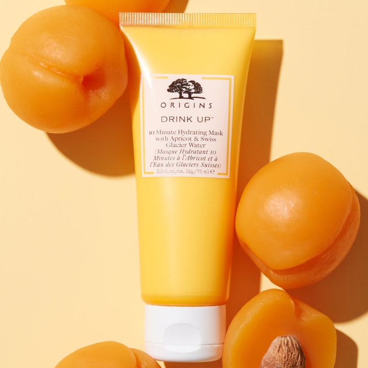 Origins Drink Up 10 Minute Mask 75 ml fugtgivende ansigtsmaske i gul tube omgivet af friske abrikoser
