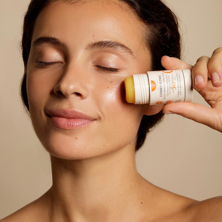 Embryolisse Sun Stick SPF50+ 15 g beskyttende solcreme i stift påføres på kinden og giver huden en sund glød