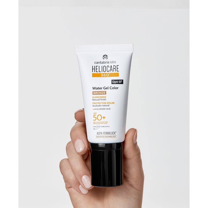 Heliocare Water Gel Color SPF 50+ Bronze 50 ml solcreme til ansigtet i hvid tube med sort låg holdt i en hånd.