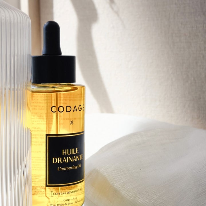 Codage Paris The Contouring Oil 100 ml drænende kropsolie i en glasflaske med sort pipette ved hvidt stof