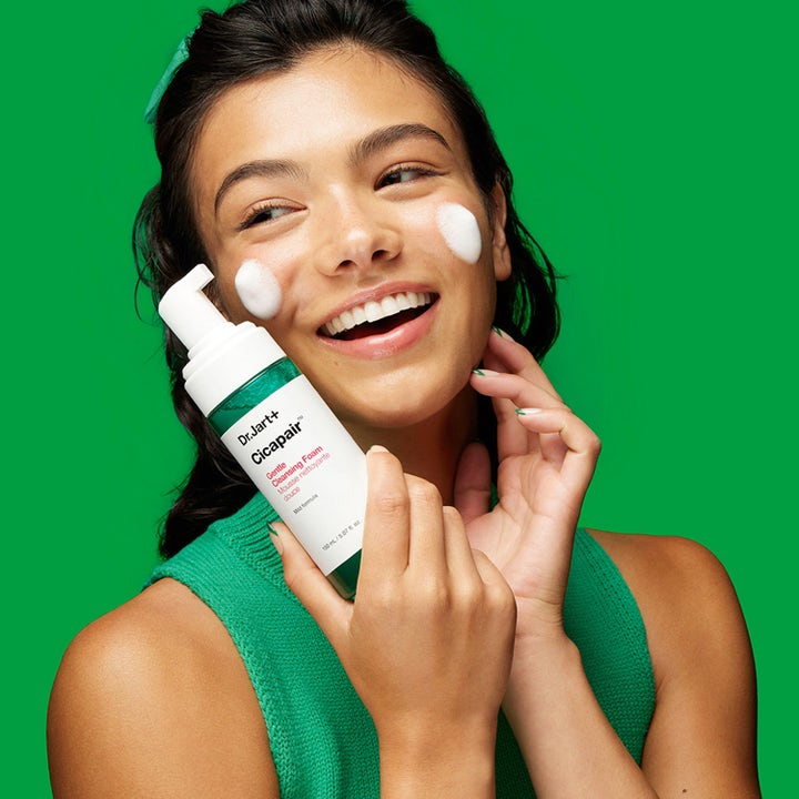 Dr.Jart+ Cicapair Gentle Cleansing Foam 150 ml beroligende ansigtsrens vist med en smilende kvinde med skum på kinderne