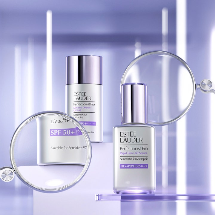 Estée Lauder Perfectionist Pro Serum 30 ml opstrammende ansigtsserum i sølvflaske vist bag et forstørrelsesglas.
