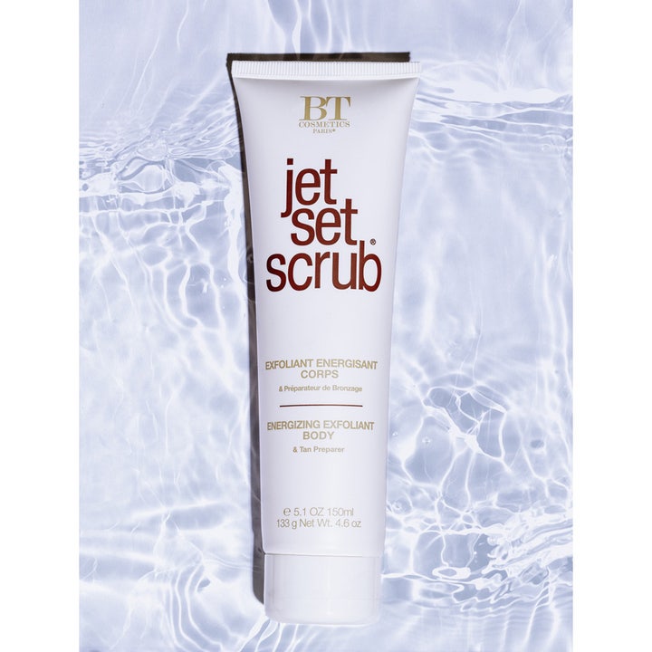 Jet Set Sun Jet Set Scrub 150 ml eksfolierende body scrub i hvid tube placeret over klart ripplende vand