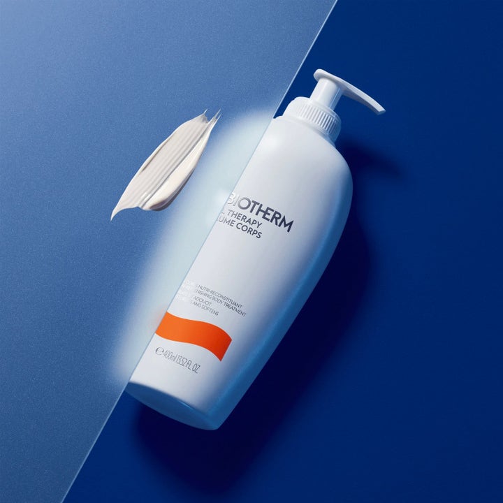 Biotherm Baume Corps 400ml blødgørende kropspleje i hvid pumpeflaske med cremet tekstur på blå baggrund