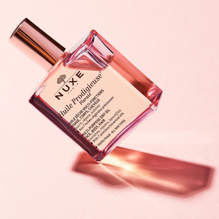 Nuxe Huile Prodigieuse Florale 50 ml nærende tørolje i lyserød glasflaske med rosaguld låg på lyserød base.