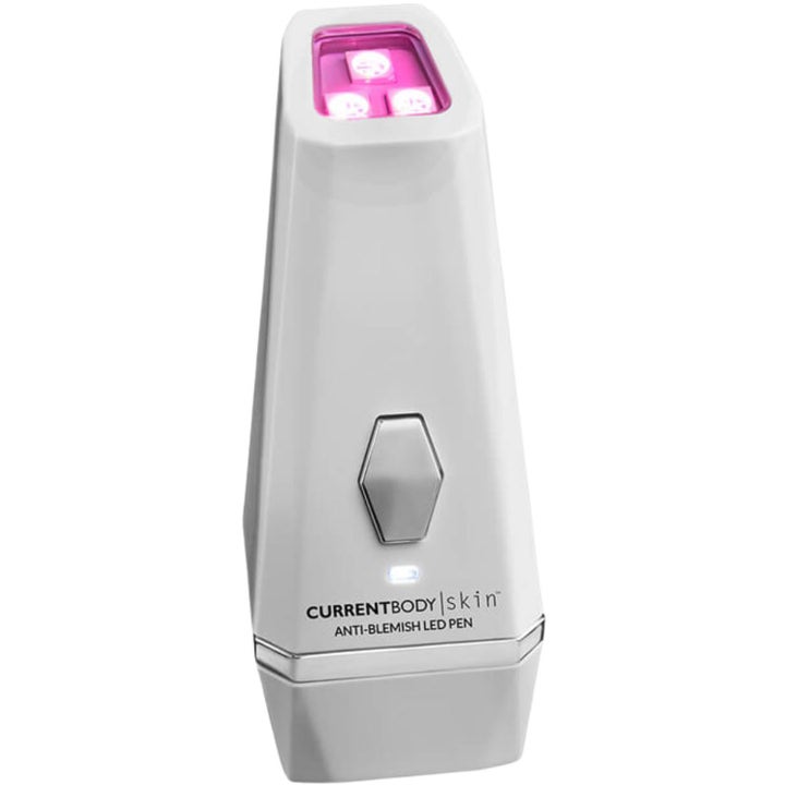 CurrentBody Skin Anti-Blemish LED Pen modvirker urenheder med lysbehandling i en hvid pen med lyserødt LED-lys og sølvknap.
