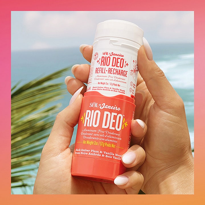 Sol de Janeiro Rio Deo 40 Deodorant Refill 57 ml aluminiumsfri deodorant holdes i hænderne mod en solrig strand.