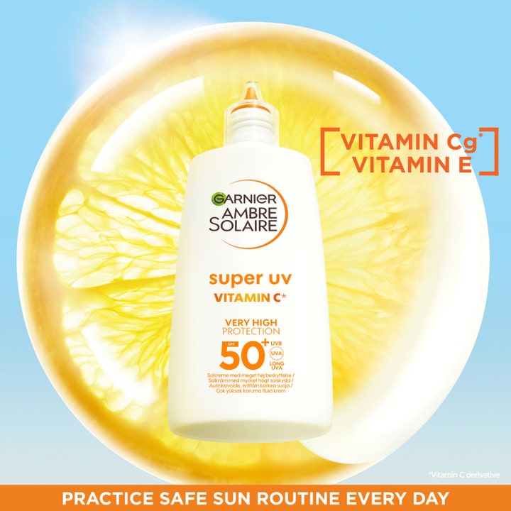 Garnier Ambre Solaire Super UV Vitamin C 40 ml solcreme med SPF 50 mod mørke pletter foran en lysende citrusskive