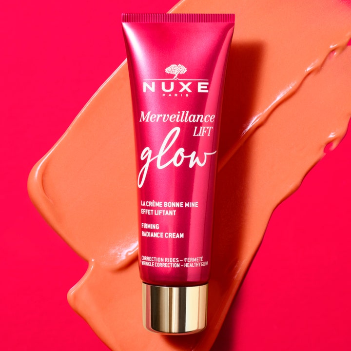 Nuxe Merveillance Lift Glow 50 ml opstrammende dagcreme i pink tube på lyserød baggrund med creme-swatch