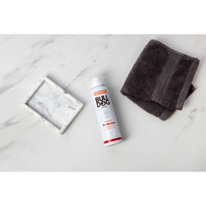 Bulldog Spray Deodorant Bergamot & Sandalwood 125 ml herredeodorant på hvid marmor ved et mørkt håndklæde.