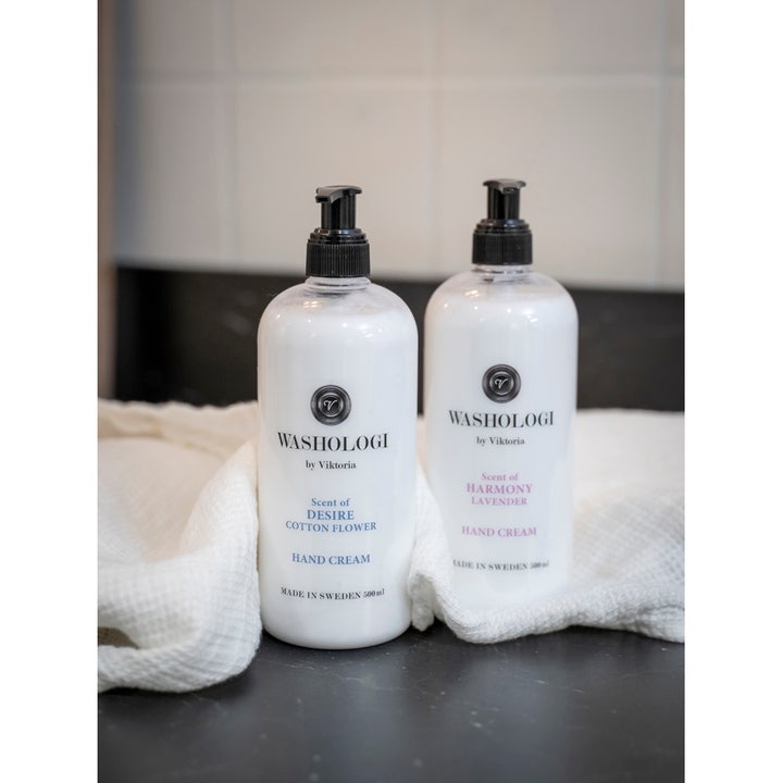Washologi Hand Cream Scent Of Desire 500 ml fugtgivende håndcreme i hvide pumpeflasker ved et blødt, hvidt håndklæde.