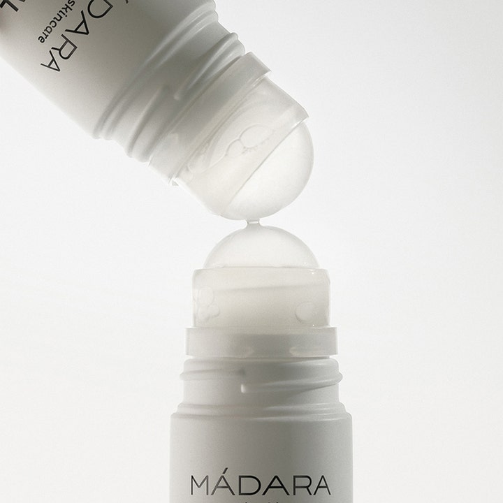 MÁDARA Herbal Deodorant 50 ml giver naturlig friskhed. Nærbillede af to hvide roll-on flasker der rører hinanden.
