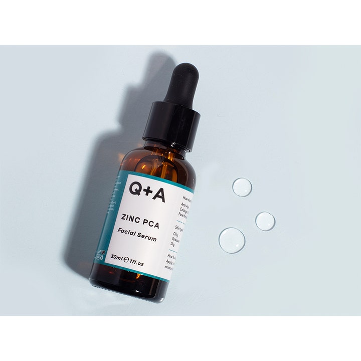 Q+A Zinc PCA Facial Serum 30 ml minimerer porer i en brun glasflaske med dråber af klar tekstur