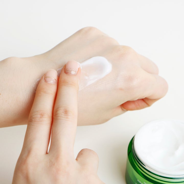 Dr. Ceuracle Tea Tree Purifine Cream 50 g beroligende dagcreme i grøn krukke med hvid tekstur på en hånd