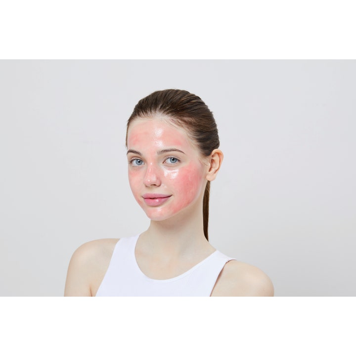 COSRX The AHA BHA PHA LHA 35 Peel 30 ml eksfolierende peeling vist som en glinsende lyserød maske på en kvinde