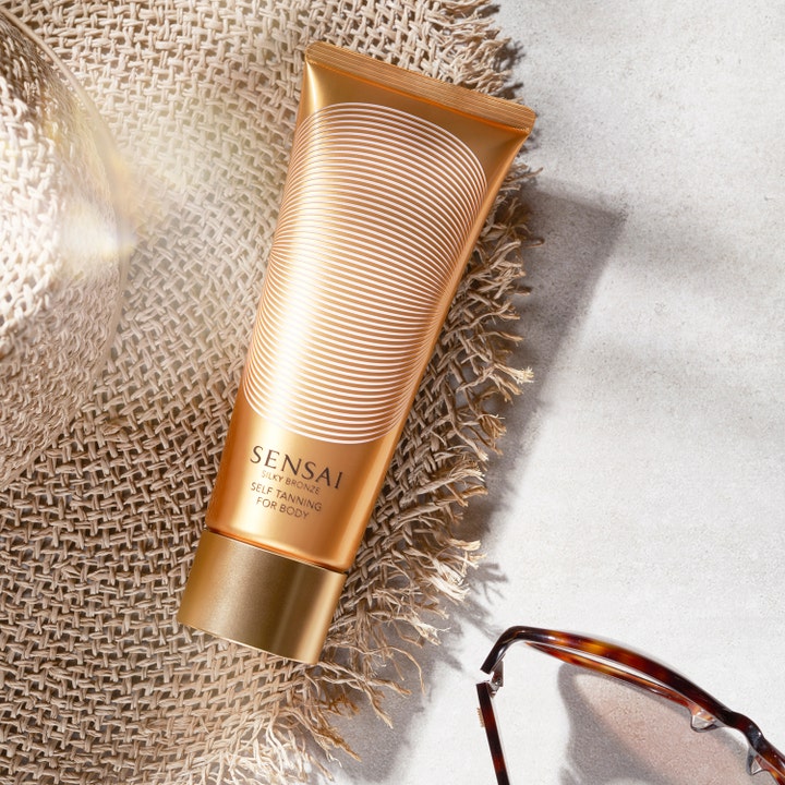 Sensai Silky Bronze Self Tanning For Body 150 ml brun uden sol i bronze tube på en stråhat med solbriller