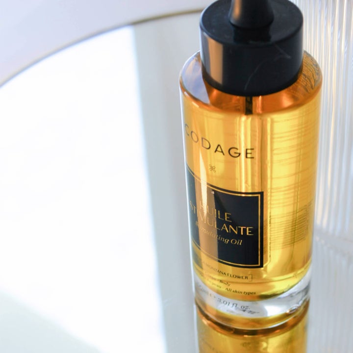Codage Paris Stimulating Oil 100 ml kropsolie i glasflaske med pipette på en spejlende overflade