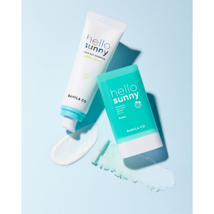 Banila Co Hello Sunny Essence Sun Stick 18,5 g SPF 50 solstick i turkis hylster med en frisk teksturprøve.